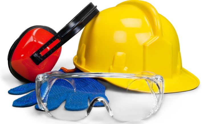 yellow hard hat, red earmuffs, blue gloves, and clear safety glasses staged against a white background, providing examples of safety tools we use in the workplace
